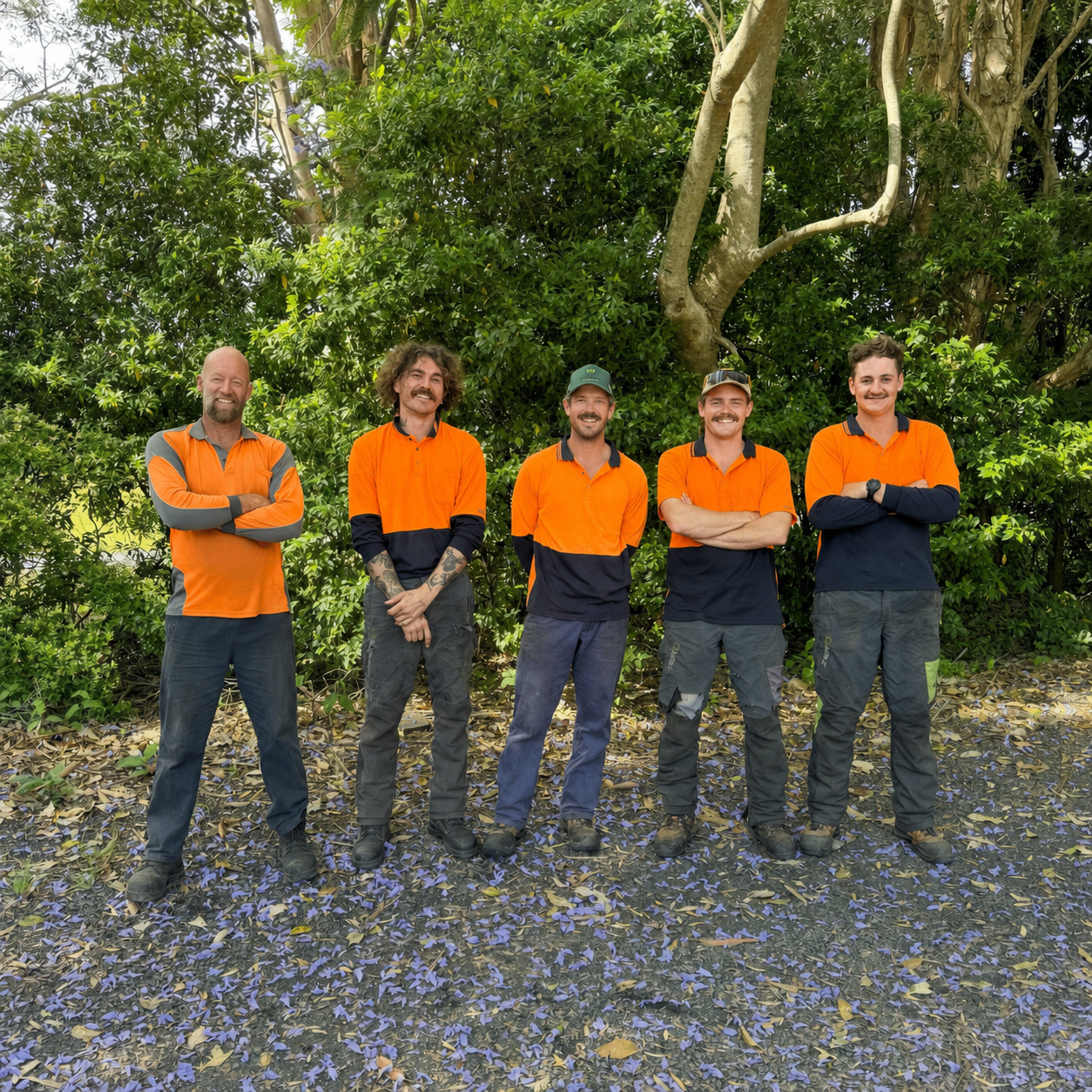 TreeBros crew standing in front of their truck and wood chipper